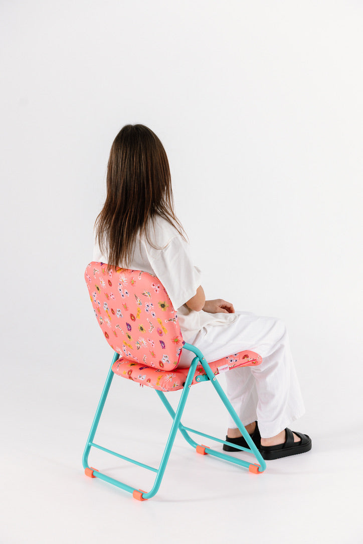 Person sitting on a colorful chair with a white background