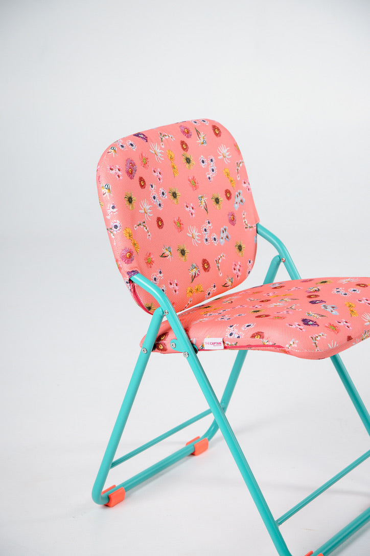 Floral-patterned chair with pink seat and backrest on a white background with green frame