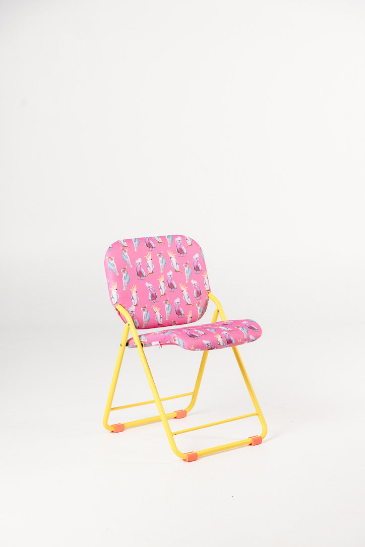 Pink chair with a colourful pattern with a yellow frame