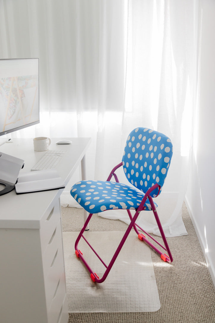 Polka dot chair in a home office setting with a desk and computer monitor.
